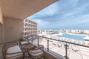 a balcony with chairs and a view of the ocean at Tolip Resort Sunrays New- Alamein in El Alamein