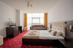 a bedroom with a large bed and a couch at HOTEL N Residence in Timişoara