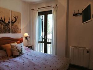 a bedroom with a bed and a sliding glass door at Amplio apartamento con jardín y piscina Herbasabina 5 in Pla de l'Ermita