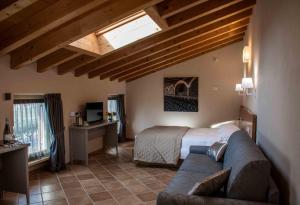 sypialnia z łóżkiem i kanapą w pokoju w obiekcie Agriturismo Relais La Casina w mieście Cavriana
