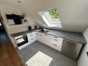 a kitchen with white cabinets and a sink and a window at HolidayHood in Treis-Karden