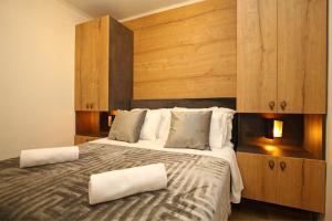 a bedroom with a large bed with two pillows on it at Apartmani Krka Rooms in Lozovac