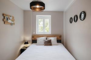 a bedroom with a large white bed with a window at Beau T3 au style moderne #2 in Embrun