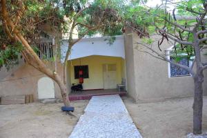 une maison avec un arbre en face dans l'établissement Jolie Maison, à Nouakchott