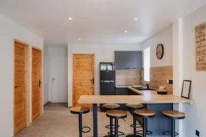 a kitchen with a wooden table and stools at Beau T3 au style moderne #2 in Embrun