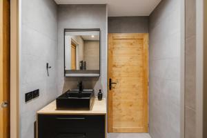 a bathroom with a black sink and a mirror at Beau T3 au style moderne #2 in Embrun +17 photos