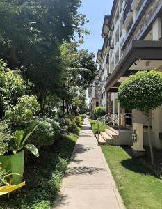 una acera junto a un edificio con árboles y arbustos en Davao 2br One Oasis Beside SM Mall-Wifi, en Davao City