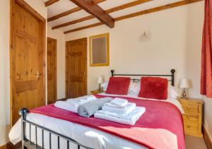 a bedroom with a bed with red and white towels on it at Oak Lodge Cottage in Grasmere