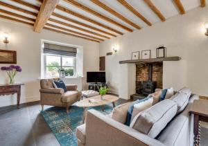 a living room with a couch and chairs and a fireplace at Fell View in Silecroft