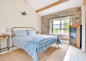 a bedroom with a bed and a stone wall at Fell View in Silecroft