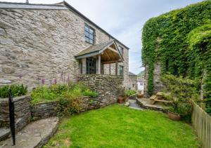 a stone house with a green yard in front of it at Fell View in Silecroft