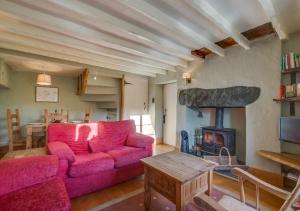 Little LangdaleにあるSlaters Cottageのリビングルーム(ピンクのソファ、暖炉付)