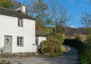 an old white house with a winding road at Slaters Cottage in Little Langdale