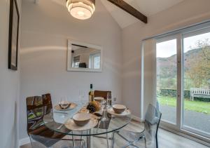 a dining room with a glass table and chairs and a window at Toffee Cottage in Chapel Stile