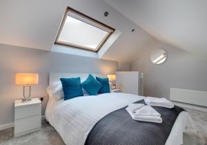 a bedroom with a bed with blue pillows and a window at Toffee Cottage in Chapel Stile