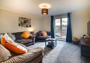 una sala de estar con 2 sofás y una puerta corredera de cristal en Stanhope en Ulverston