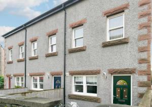 a gray brick building with green doors and windows at Stanhope in Ulverston