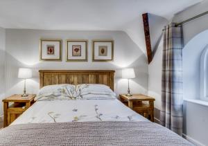a bedroom with a bed with two lamps on two tables at Brookside Cottage in Windermere