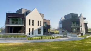 dos edificios con césped delante de ellos en CLIFF Trzęsacz - sea view apartments, en Trzęsacz 128 fotos más