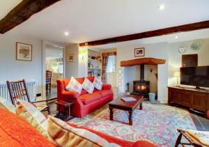 a living room with a red couch and a fireplace at Crag Head Cottage in Ambleside