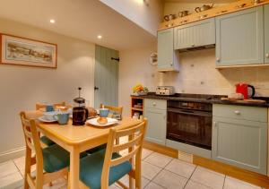 a kitchen with a wooden table and a table and chairs at Tabithas Cottage in Chapel Stile