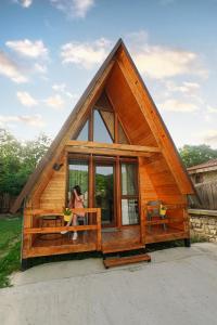 a woman sitting on a porch of a tiny house at Mtskheta Cabin in Mtskheta