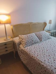 sypialnia z łóżkiem i lampką na stoliku nocnym w obiekcie Apartamentos Playa de Moncofa w mieście Moncófar