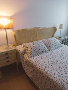a bedroom with a bed and a lamp on a night stand at Apartamentos Playa de Moncofa in Moncófar +10 photos