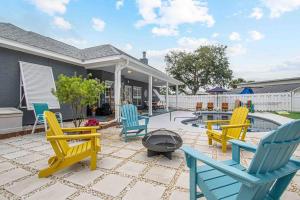 a patio with blue and yellow chairs and a fire pit at Luxurious 4BR Beach House with Pool in Panama City Beach