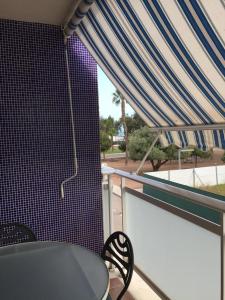 a balcony with a table and a blue and white canopy at Apartamentos Playa de Moncofa in Moncófar