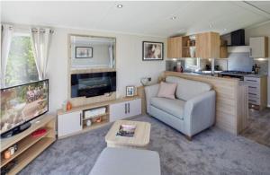 a living room with a couch and a tv at Home Farm Park - Static Caravans in Burgh le Marsh