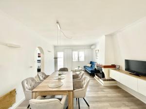 uma sala de estar com uma mesa e cadeiras e uma televisão em Villa Balcones Torrevieja by Villas&You em Torrevieja