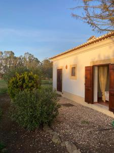 mały biały dom z drzwiami i ogródkiem w obiekcie Monte da Azinheira w mieście Ourique