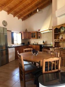 cocina con mesa de madera con sillas y nevera en Monte da Azinheira, en Ourique
