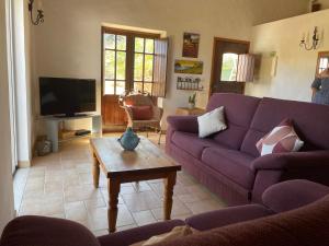 Sala de estar con sofás morados y mesa de centro en Monte da Azinheira, en Ourique