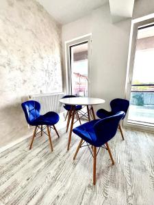 uma sala de jantar com cadeiras azuis e uma mesa em Vik’s Apartament Sunrise Residence em Mangalia
