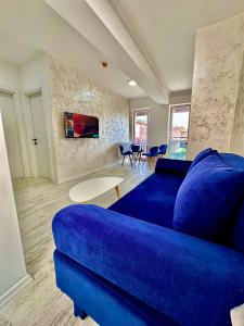 uma sala de estar com um sofá azul e uma mesa em Vik’s Apartament Sunrise Residence em Mangalia