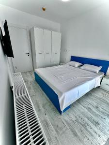 um quarto com uma cama grande e uma cabeceira azul em Vik’s Apartament Sunrise Residence em Mangalia