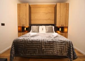 1 dormitorio con 1 cama grande y cabecero de madera en Apartmani Krka Rooms en Lozovac