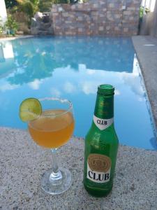 - une boisson et une bouteille de bière près de la piscine dans l'établissement Aqualina, à Don Juan