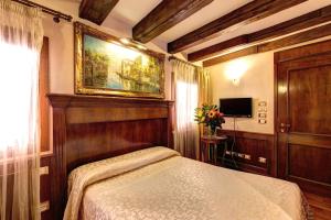 sypialnia z łóżkiem i obrazem na ścianie w obiekcie Palazzo La Scala w Wenecji