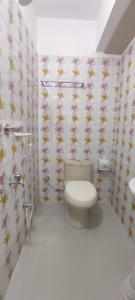 a bathroom with a toilet and flowers on the wall at Hotel Prime Inn Mirpur 10 in Dhaka