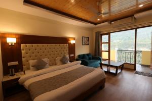 una camera da letto con un letto grande e una grande finestra di Riverside Resorts a Devaprayāg Altre 84 foto