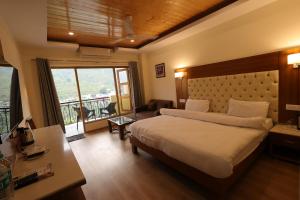 a bedroom with a bed and a large window at Riverside Resorts in Devaprayāg
