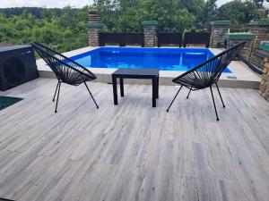 two chairs and a table in front of a swimming pool at Vila Sava in Jarak