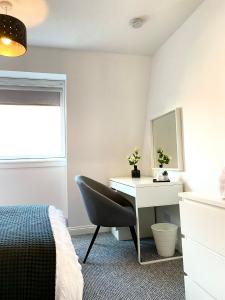 um quarto com uma secretária, uma cama e um espelho em 3 bedroom - 2 bathroom Townhouse in Corstorphine Near Murrayfield Stadium - Direct Bus To Edinburgh City Centre in 20 Minutes - Two Private Parking Spaces - Private Sunny Garden - Recently Refurbished em Edimburgo