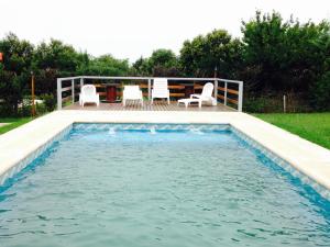 una piscina con sillas y una mesa en una terraza en Jasy Cabañas in 