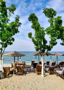 a beach with chairs and umbrellas and the ocean at Kymata Hotel in Platamonas