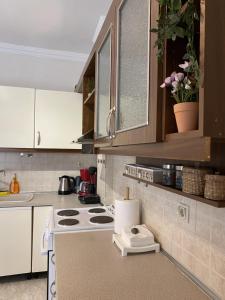 a kitchen with white cabinets and a stove top oven at Sweet Home Ano Poli in Thessaloniki