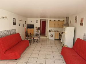 a living room with a red couch and a kitchen at Casa Prescilia in Lumio